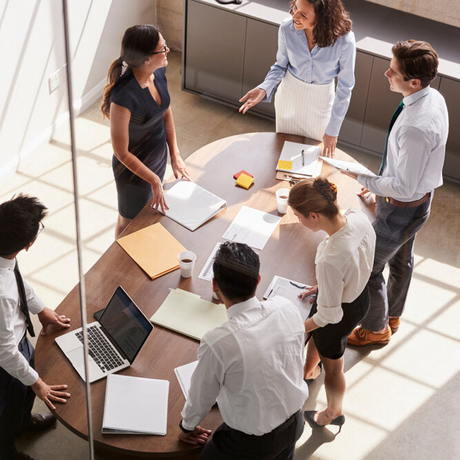 Female,Manager,In,Team,Meeting,,Elevated,View,Through,Window